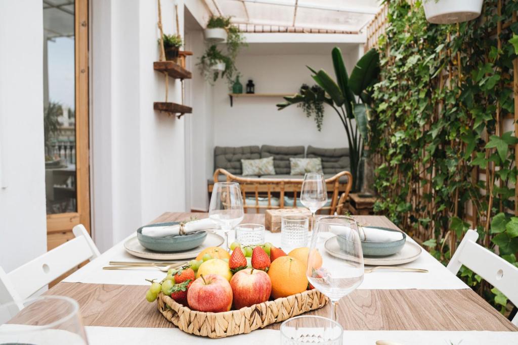 a table with a basket of fruit and wine glasses at HA Balmes Terrace Apartments in Barcelona