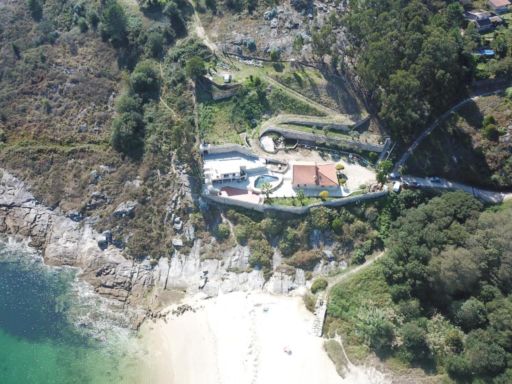 een luchtzicht op een huis op een klif naast het strand bij CASA PLAYA DE LIMENS in Cangas de Morrazo