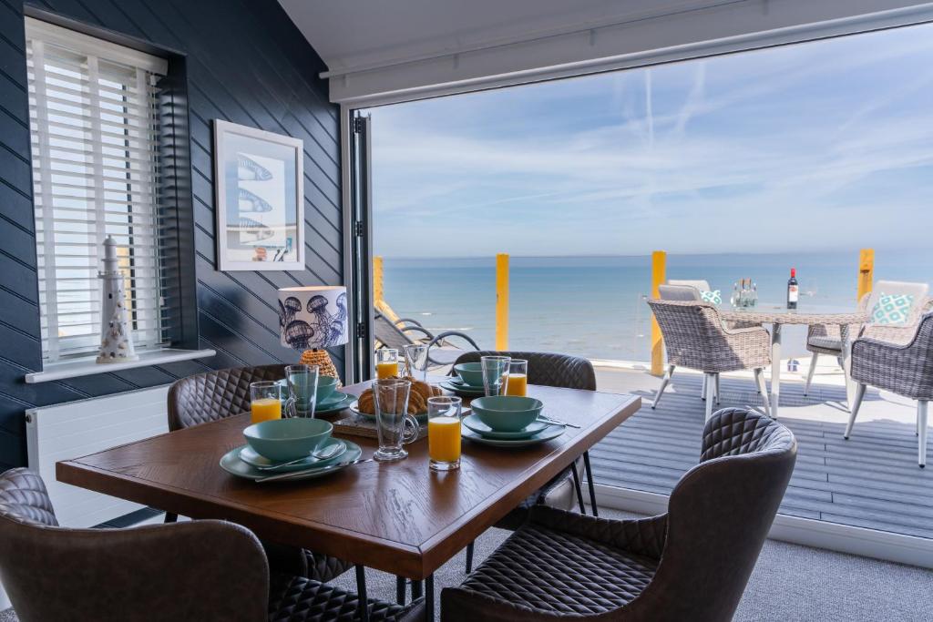 a dining room with a table and chairs and the ocean at No.1 The Prom in Westward Ho