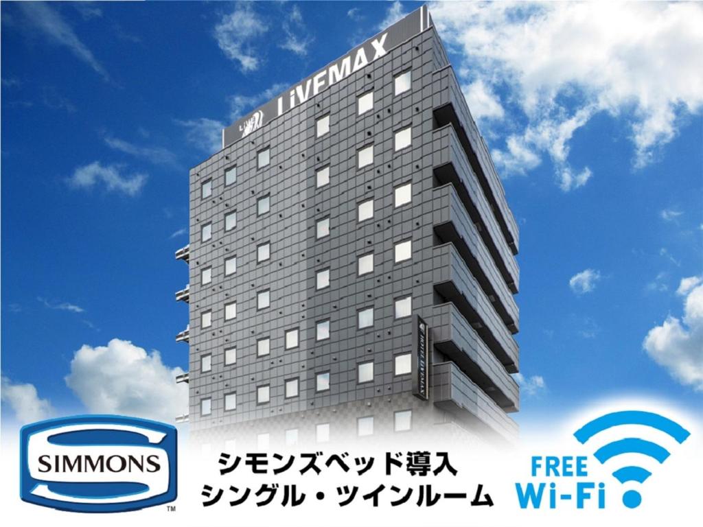 um edifício com um sinal na lateral em HOTEL LiVEMAX Okayama em Okayama