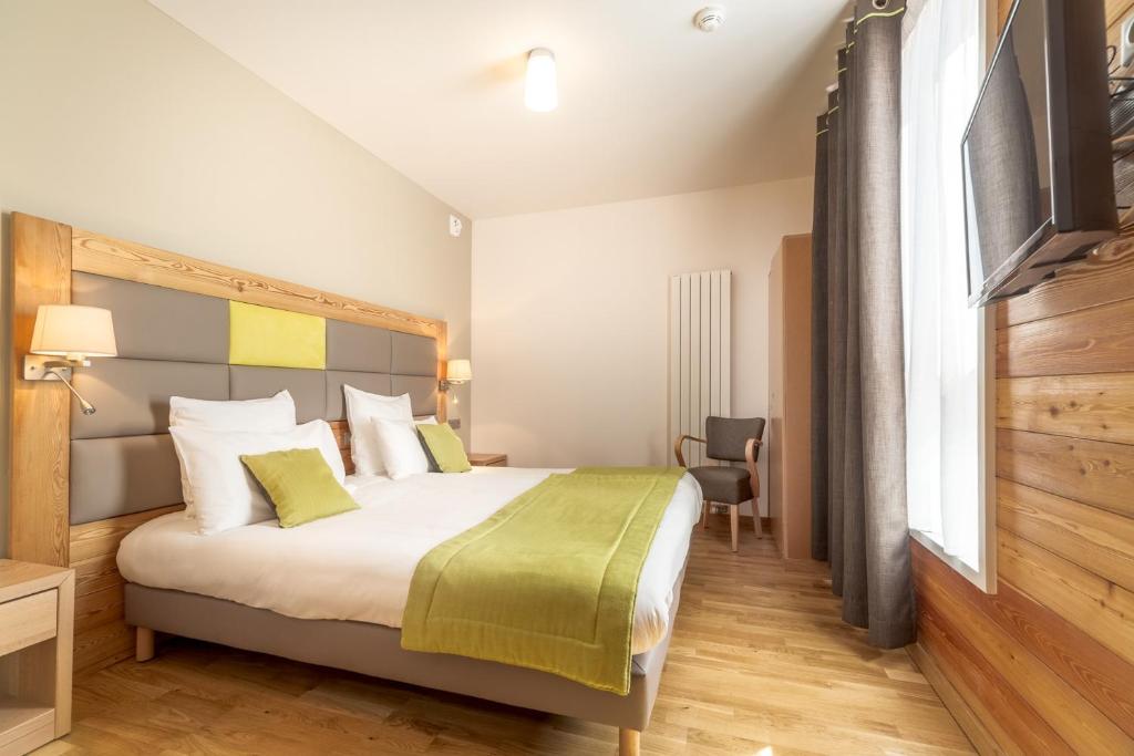 Un dormitorio con una cama grande con una manta verde. en La Bessannaise, en Bessans