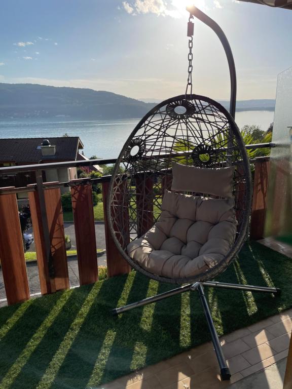 una sedia a dondolo su un balcone con vista sull'oceano di La lumière du lac a Veyrier-du-Lac