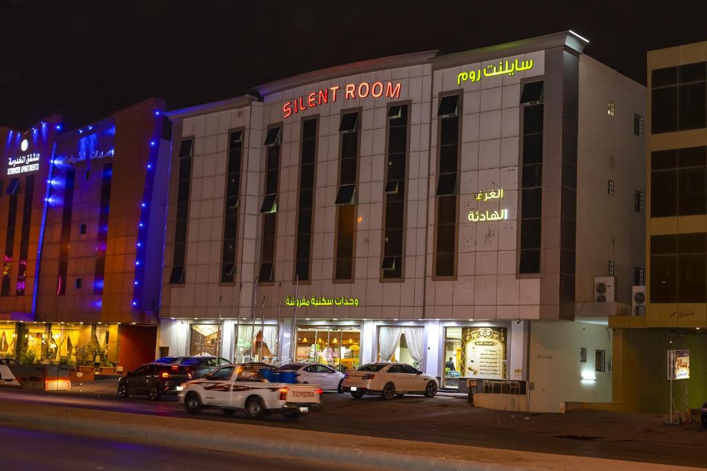 a large building with cars parked in front of it at Silent Room 1 By Quiet Rooms in Riyadh