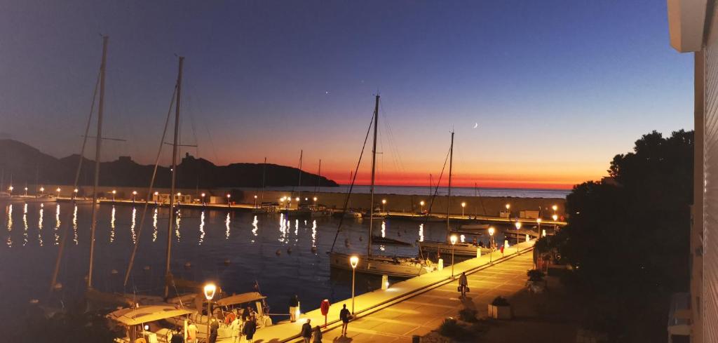 un quai avec des bateaux dans l'eau la nuit dans l'établissement Les pieds dans l'eau sur l'Ile du Frioul, à Marseille