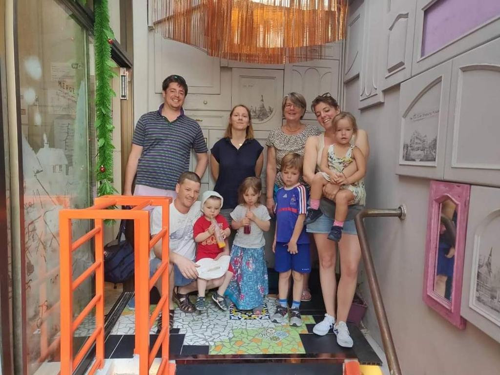 a family posing for a picture in a room at Merge Hostel in Bangkok