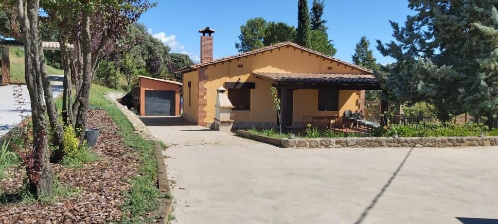 una pequeña casa amarilla con garaje en Casa Climent, en Aviá