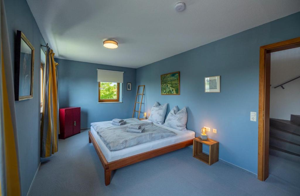 a bedroom with a large bed with blue walls at Exklusives Josenhaus mit See- und Alpenblick & Gartensauna in Nonnenhorn