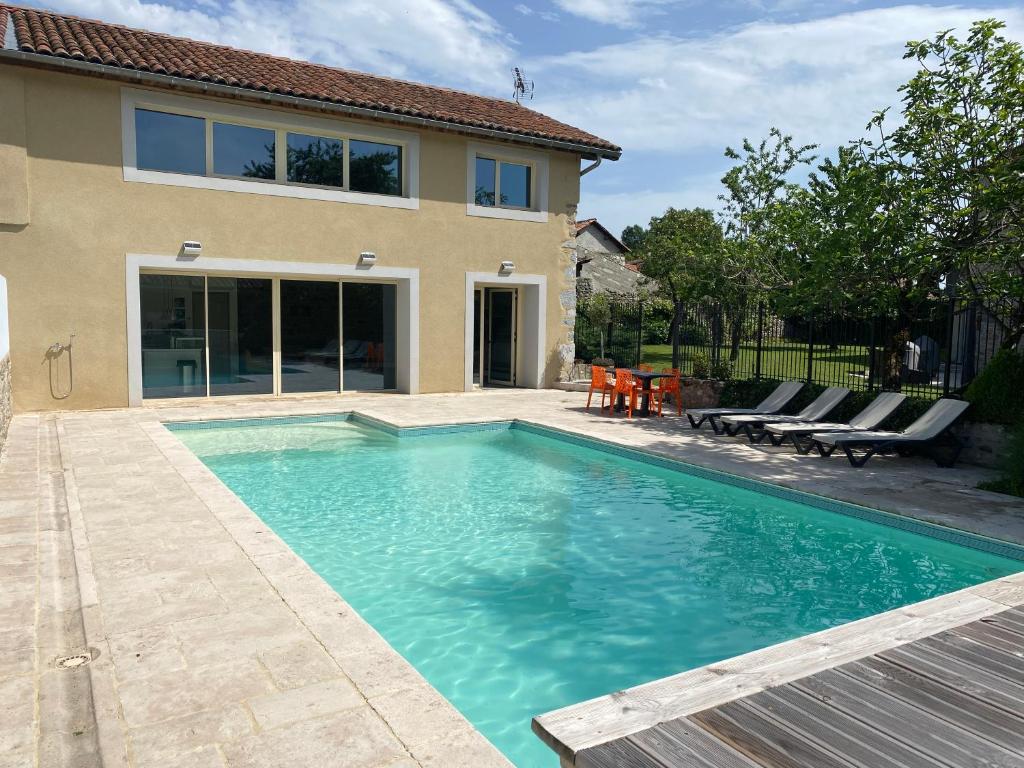 a swimming pool in front of a house at Gîtes du Bonheur in Ausson