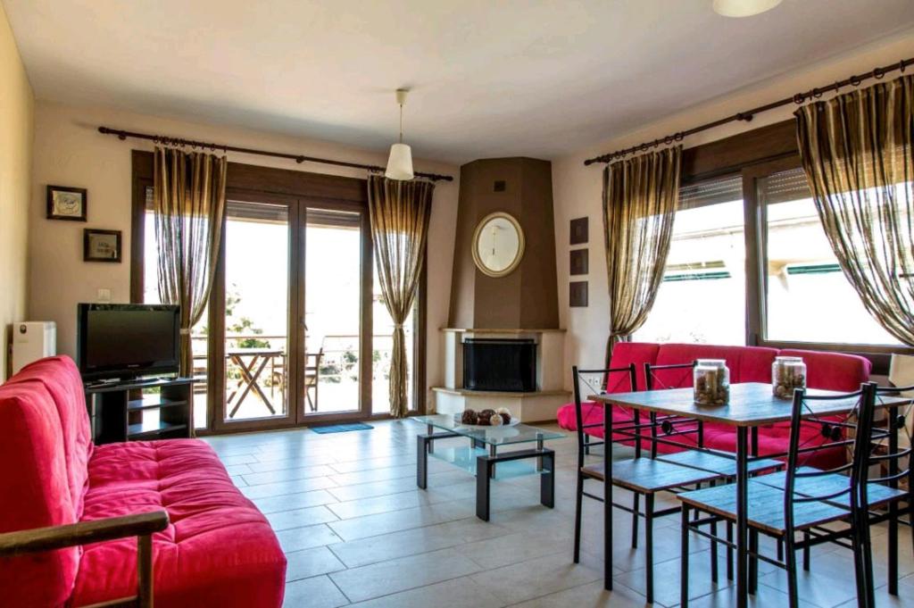 a living room with red couches and a table at Canal Luxury Apartments in Nea Potidaea