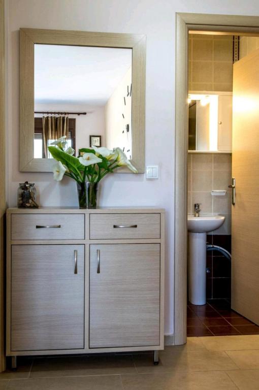 a bathroom with a dresser with a mirror and a sink at Canal Luxury Apartments in Nea Potidaea
