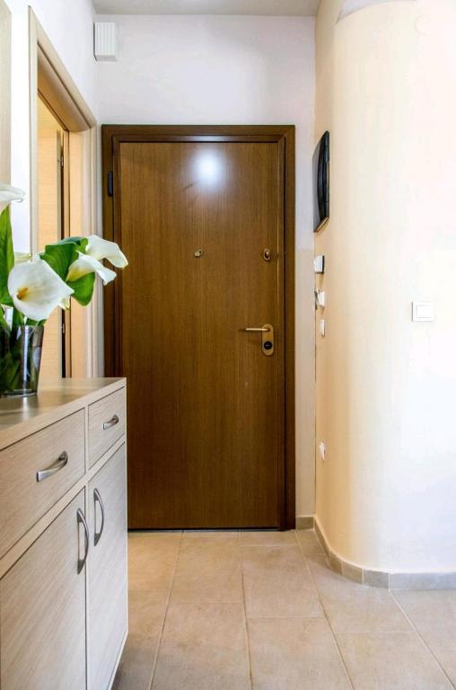 a hallway with a wooden door and a room at Canal Luxury Apartments in Nea Potidaea
