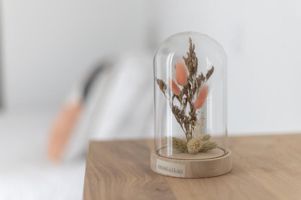 a glass jar with a flower in it on a table at Hôtel Porte Mars Reims Gare Centre Arena in Reims