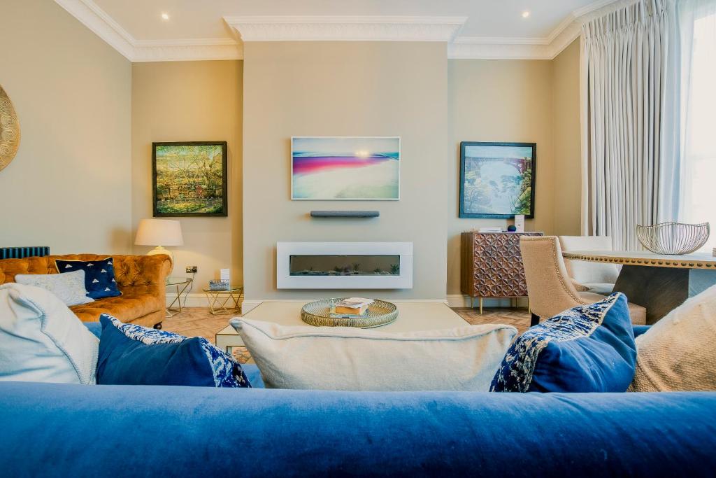 a living room with a blue couch and a fireplace at Derwent House Apartments in Scarborough