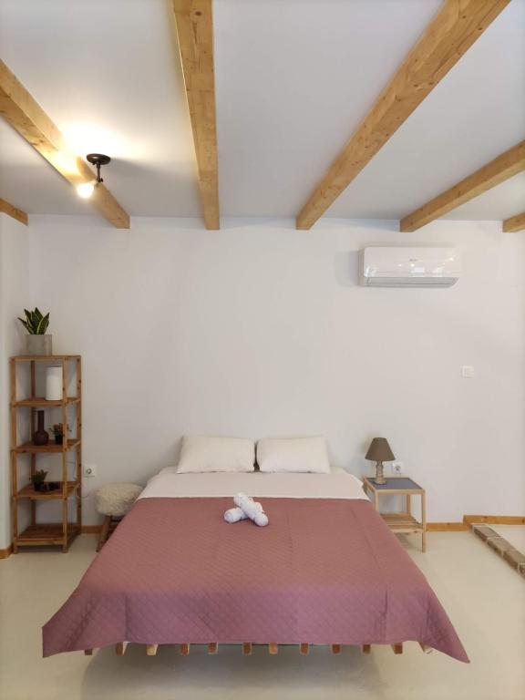 a bedroom with a large bed with a purple blanket at Zaira's Apartment Corfu Town in Agios Rokkos