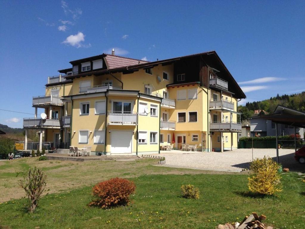 a large yellow building with a black roof at Carlotta Apartment in Reifnitz