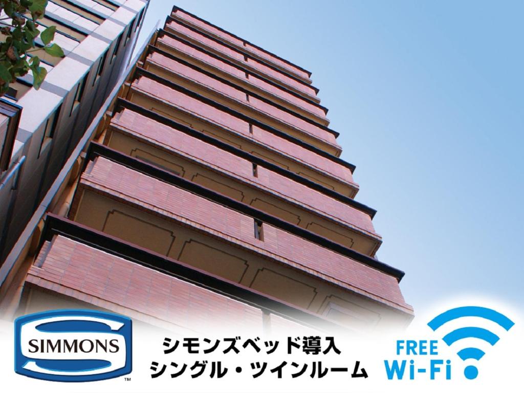 un edificio alto con un cartel en el costado en HOTEL LiVEMAX Kyoto Ekimae, en Kioto