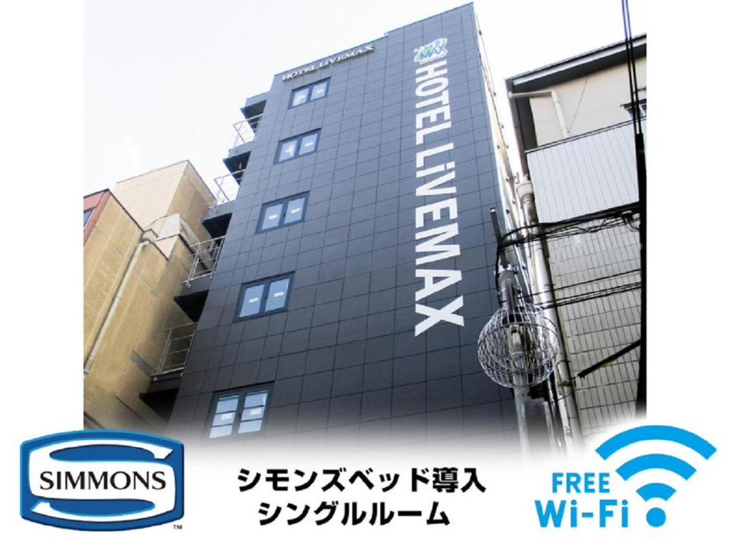 a building with a sign on the side of it at HOTEL LiVEMAX Umeda Doyama in Osaka