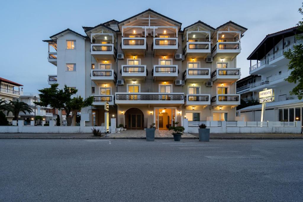 un gran edificio con balcones en un lateral en Bemyguest Comfort Zefyros, en Neoi Poroi