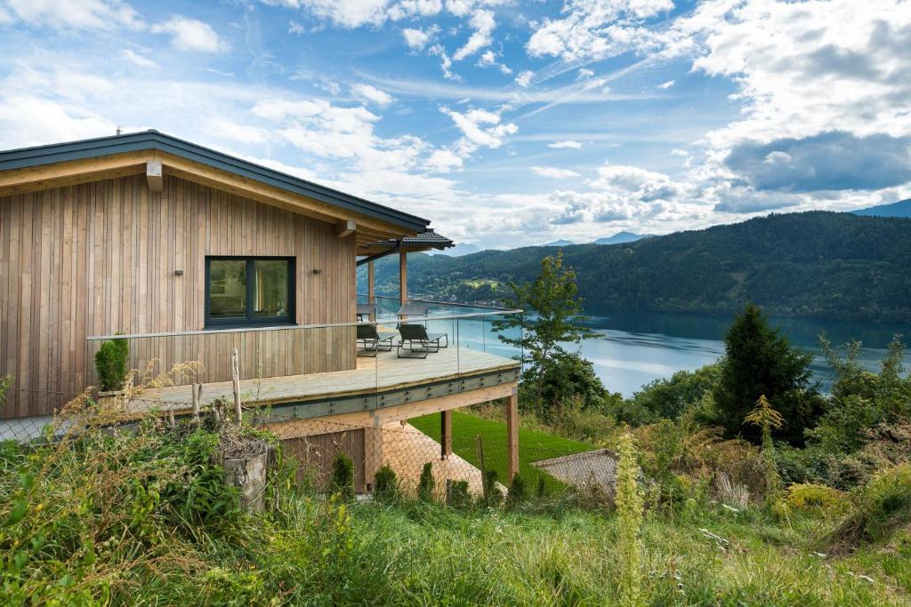 a house with a deck with a view of a lake at Chalet Seeblick in Millstatt