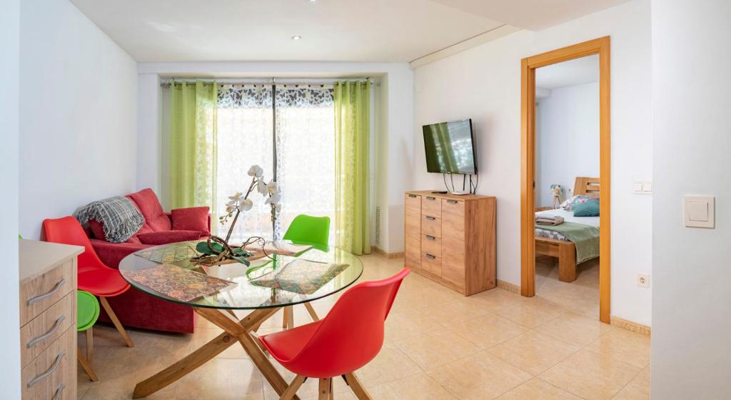 a living room with a table and red chairs at Parrot’s House in Lloret de Mar