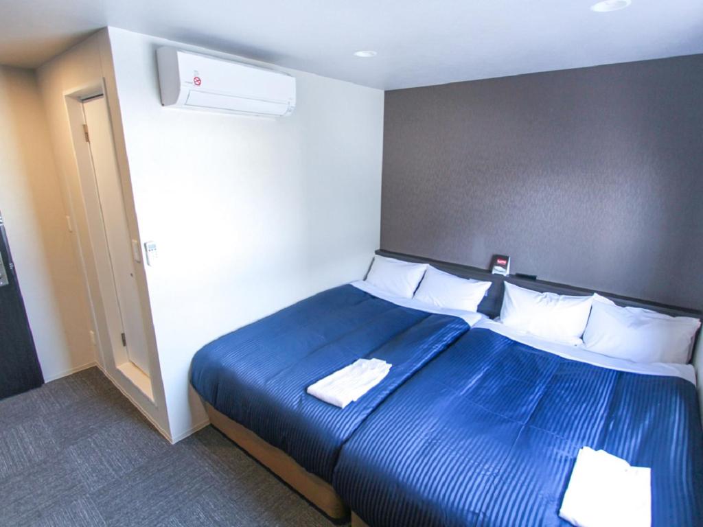Postel nebo postele na pokoji v ubytování HOTEL LiVEMAX Okayama West