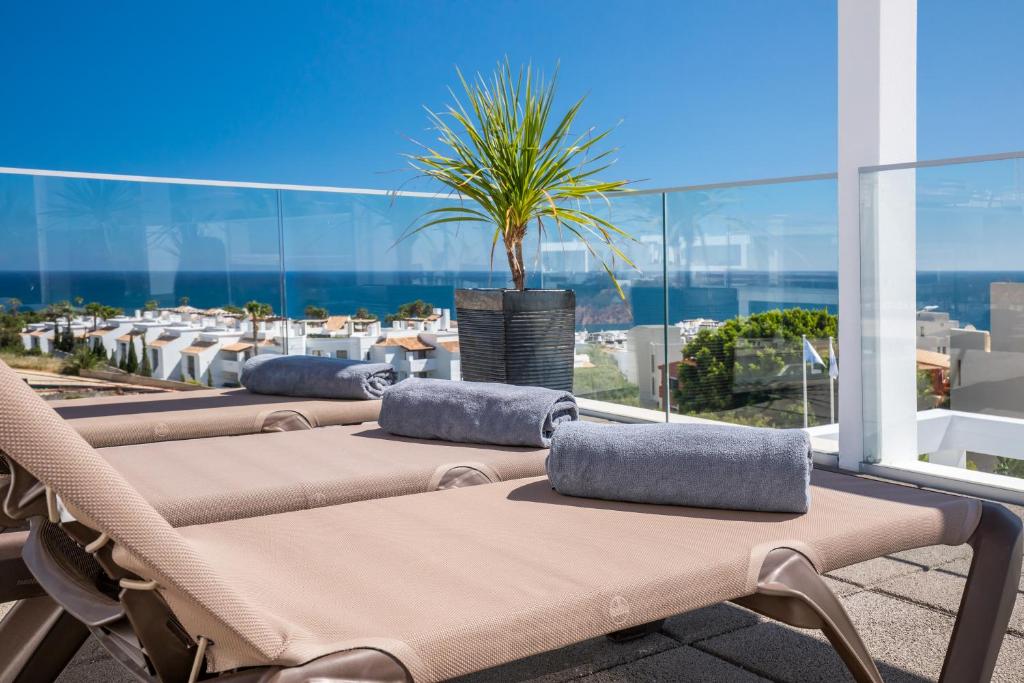 a row of chaise lounge chairs on a balcony with a view of the ocean at Lagos Atlantic Hotel in Lagos