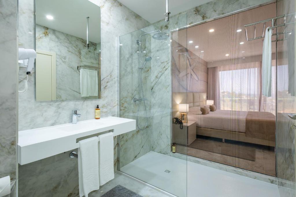 a bathroom with a sink and a shower at Lagos Atlantic Hotel in Lagos