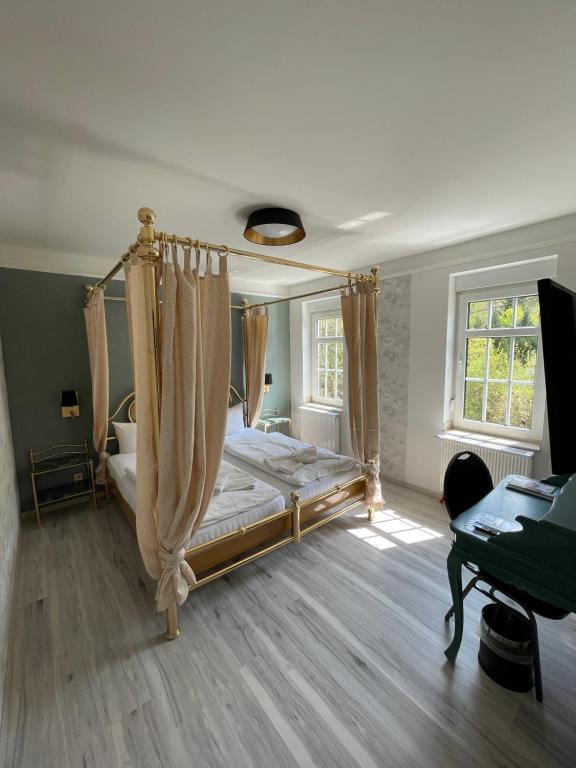 um quarto com uma cama de dossel e uma secretária em Haus Hennesburg, garni em Eisenach