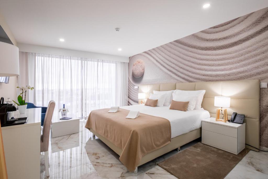 a bedroom with a large bed with a large window at Lagos Atlantic Hotel in Lagos