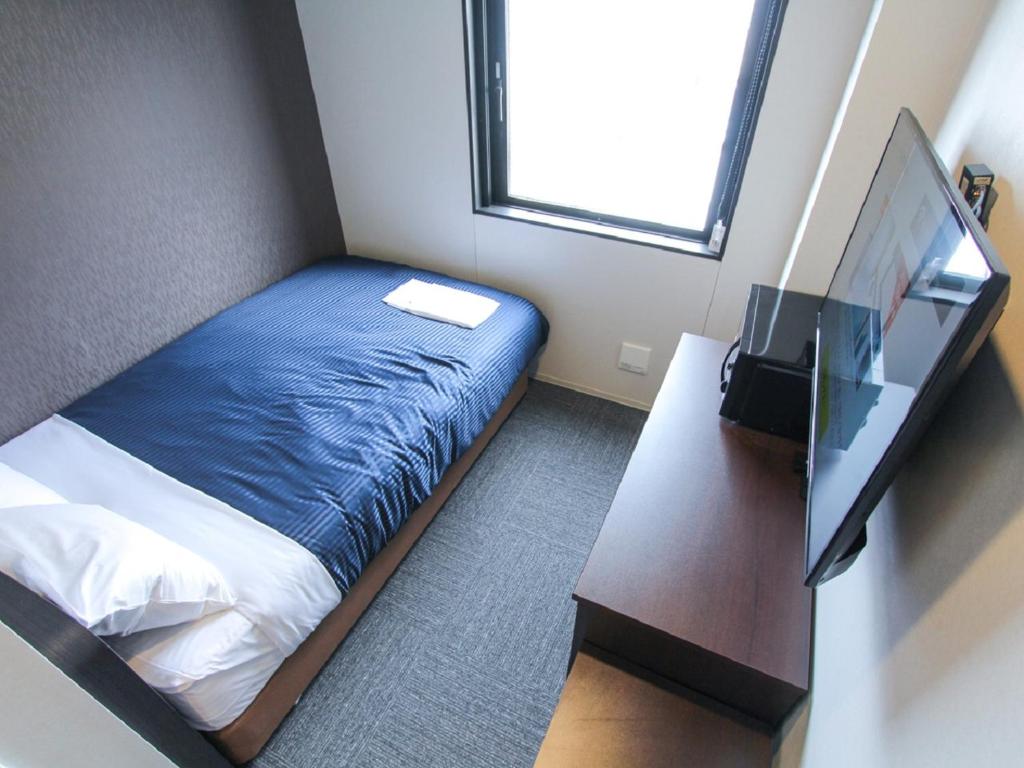 Postel nebo postele na pokoji v ubytování HOTEL LiVEMAX Okayama West