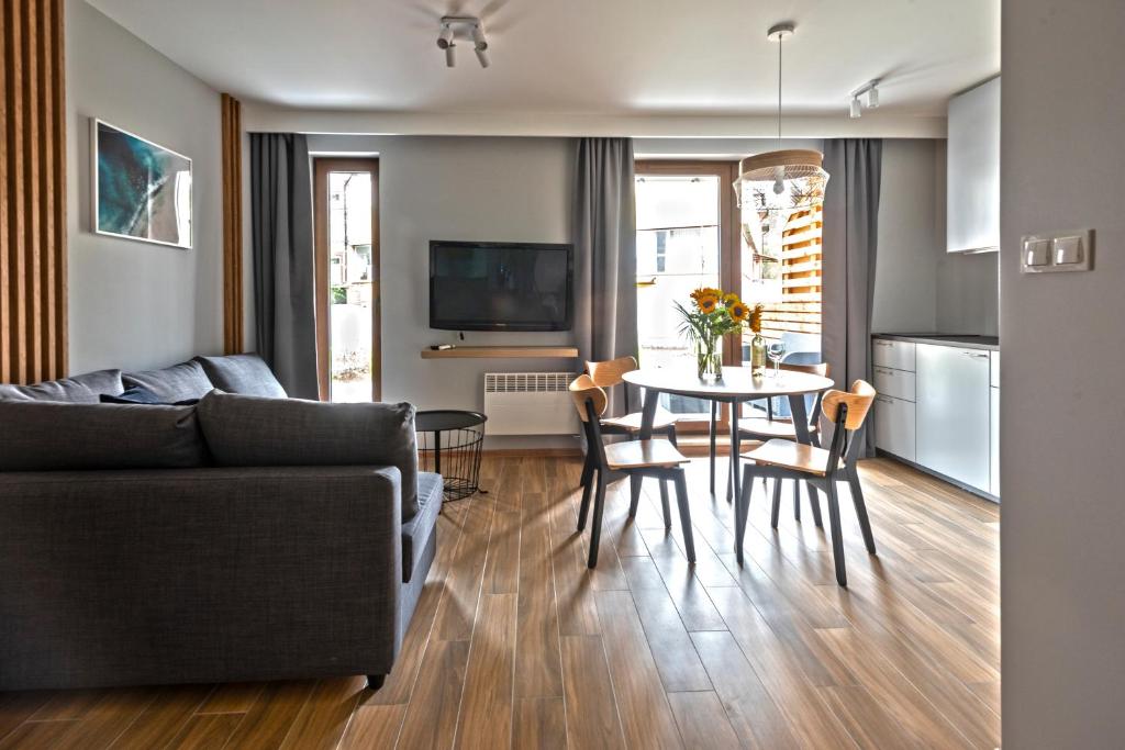 a living room with a couch and a table at Apartament Baltic Park Stegna - taras in Stegna