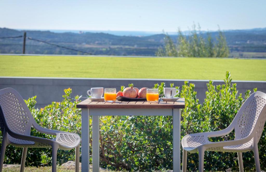 a table with a bowl of fruit and two chairs at Mas Ses Vinyes - Adults Only in Begur