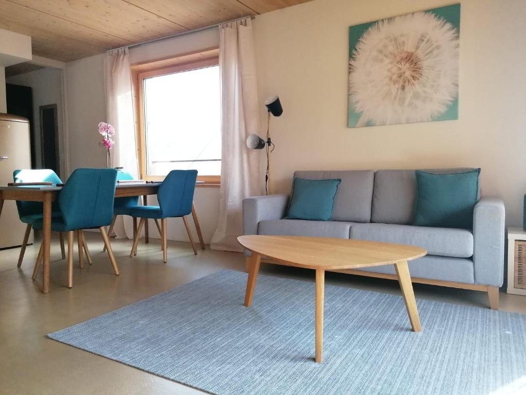 Easy-Living Kriens Apartments في لوتزيرن: غرفة معيشة مع أريكة وطاولة