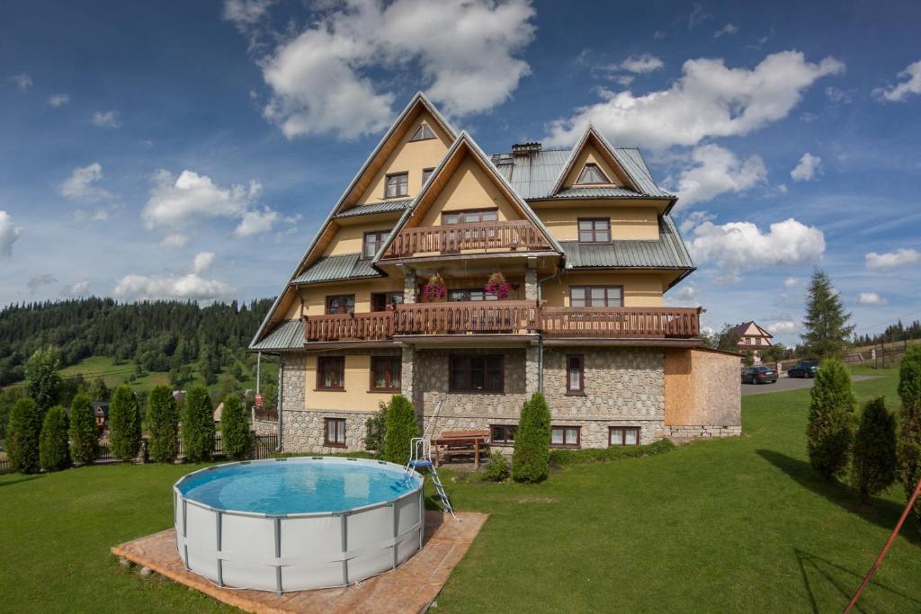uma casa grande com uma piscina em frente em Dom Wczasowy Jesionkówka em Poronin