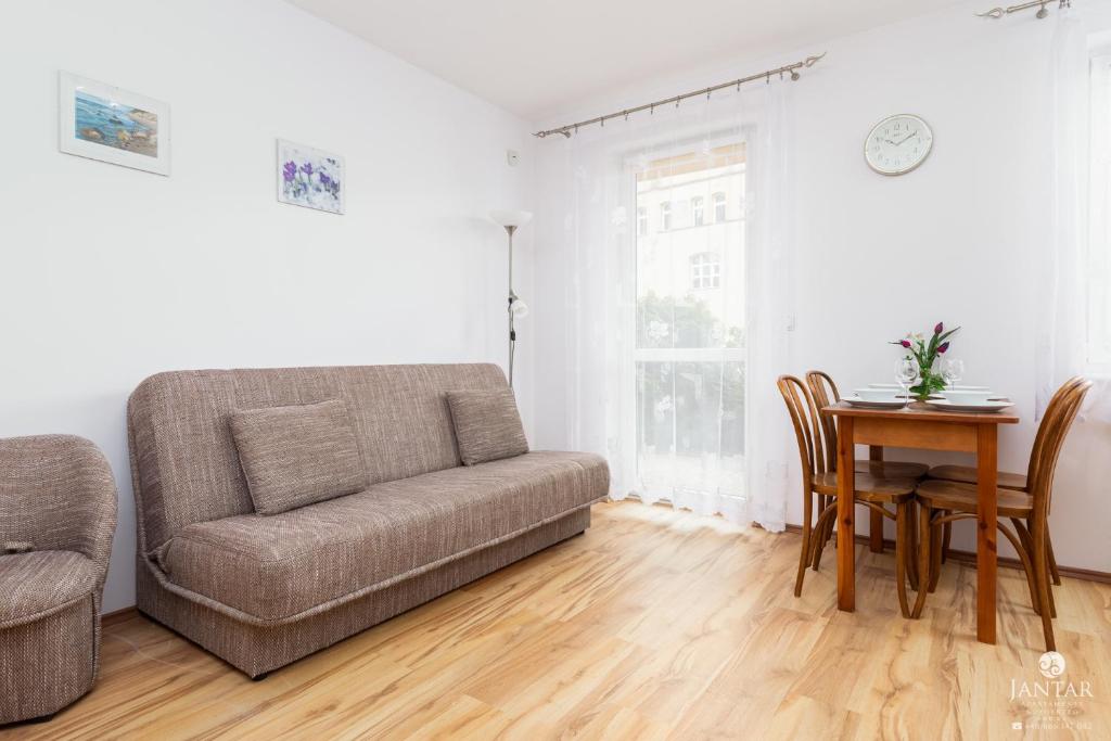 a living room with a couch and a table at Jantar Apartamenty - Uzdrowisko Kołobrzeg in Kołobrzeg