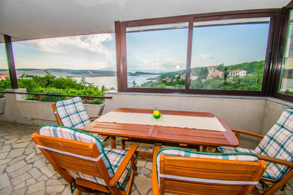 a table and chairs on a balcony with a view at Apartments Ivanica and Mirela in Jadranovo