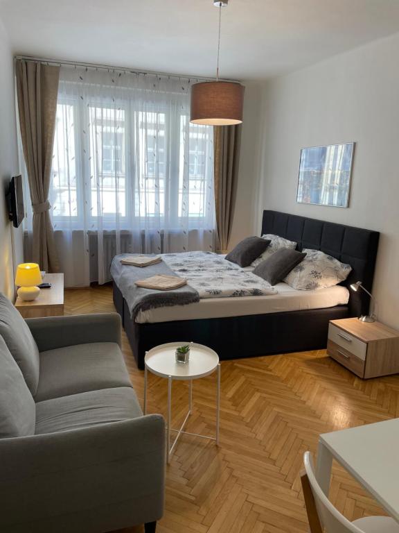 プラハにあるAgnes - Romance in city II.のベッドルーム1室(ベッド1台、ソファ、テーブル付)