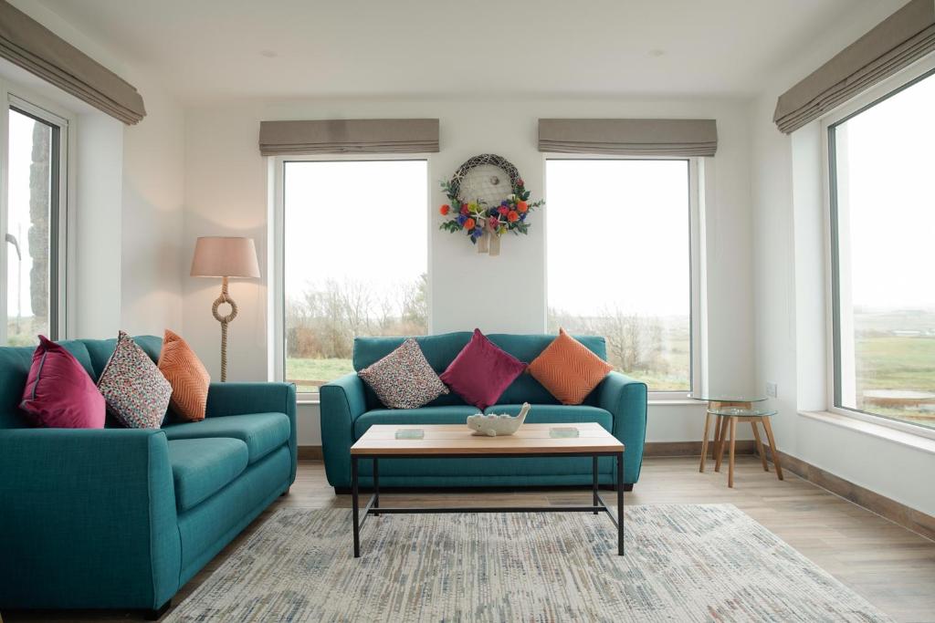 a living room with a blue couch and red pillows at Radharc na Mara in Doolin