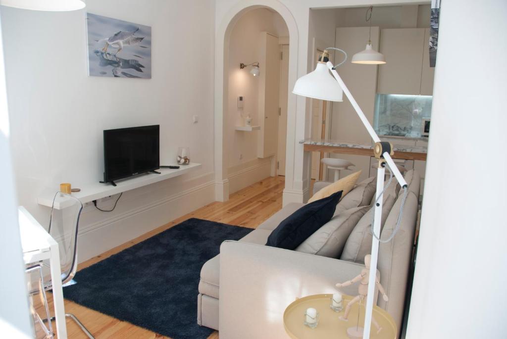 a living room with a couch and a tv at OportoView Alegria Apartment in Porto