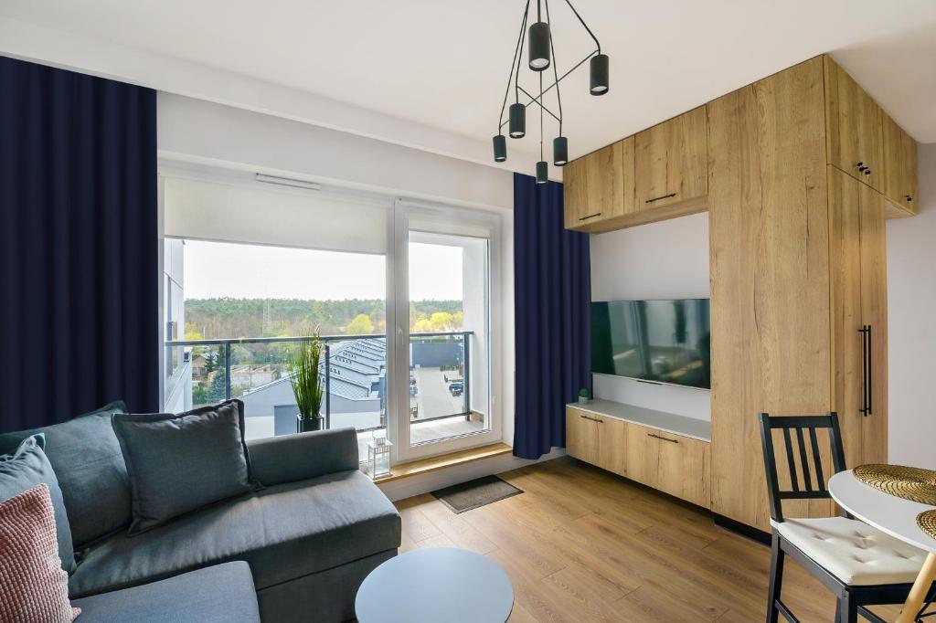 a living room with a couch and a large window at ALFA 14 in Włocławek