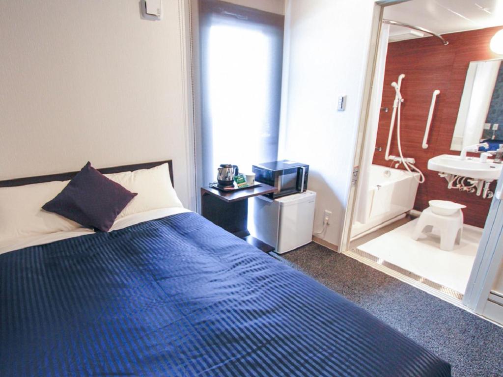Postel nebo postele na pokoji v ubytování HOTEL LiVEMAX Kobe Sannomiya