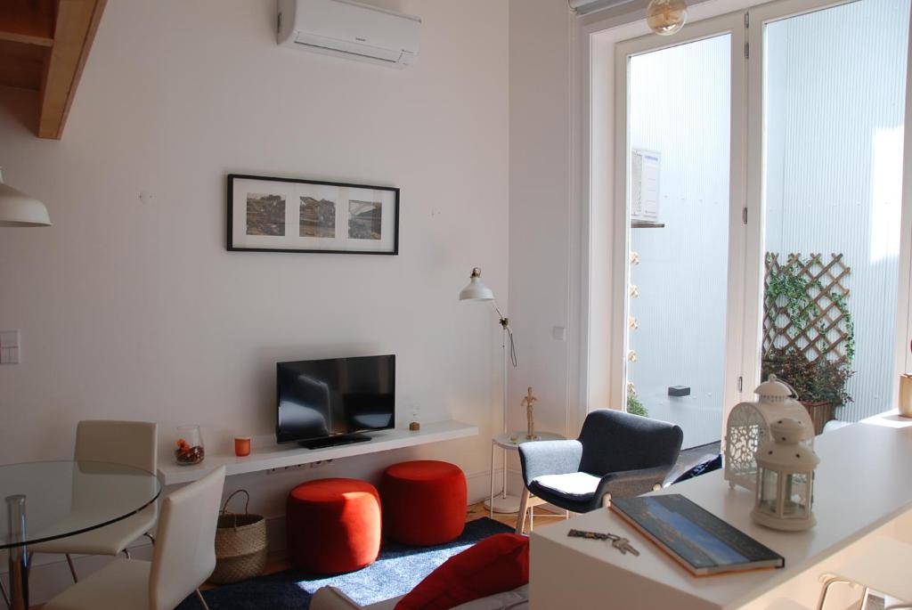 a living room with a tv and a table and chairs at OportoView Premium Apartment in Porto