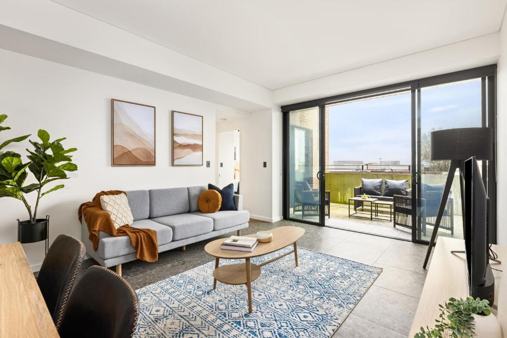 a living room with a couch and a table at Cinema Suites Apartments by Urban Rest in Sydney