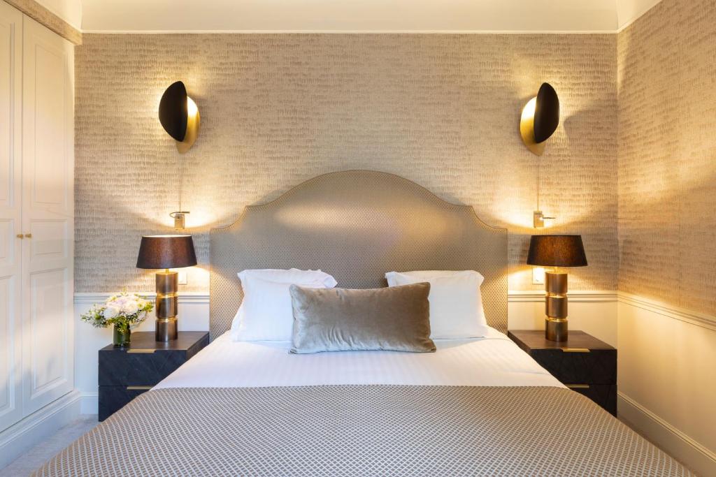 um quarto com uma grande cama branca e 2 candeeiros em Hotel Residence Foch em Paris