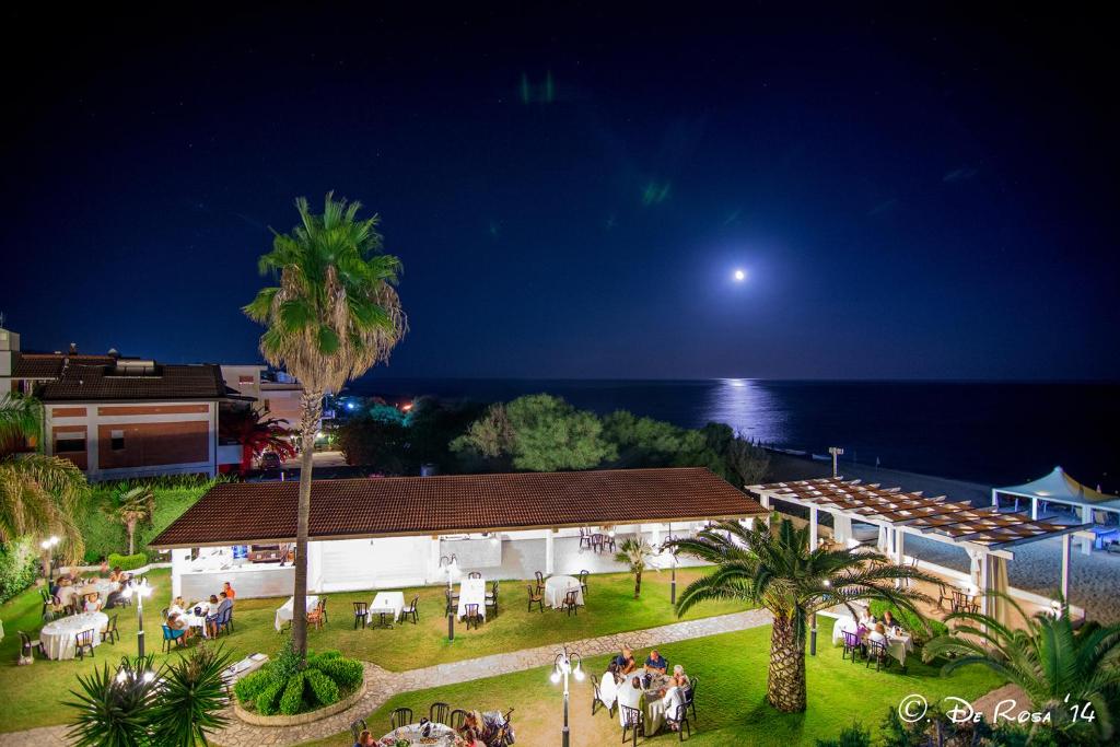 una vista su una spiaggia di notte con luna piena di Hotel Federica a Riace Marina