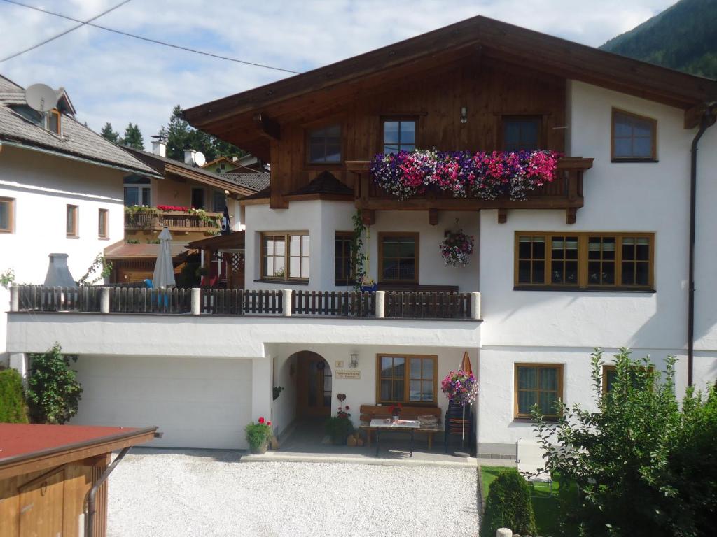 a house with a balcony with flowers on it at Ferienwohnung Krößbacher in Neustift im Stubaital
