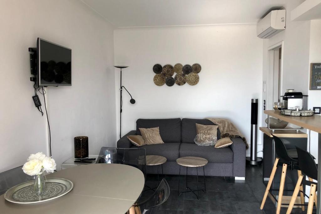 een woonkamer met een bank en een tafel bij Cosy 42m With Balcony Nice View And Wifi in Cannes