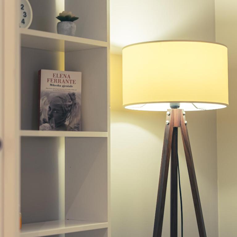 a lamp in a room next to a book shelf at Garden Boutique B&B in Tirana