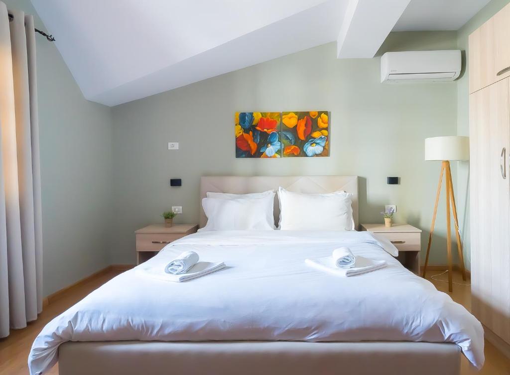 a bedroom with a white bed with two napkins on it at Garden Boutique B&B in Tirana