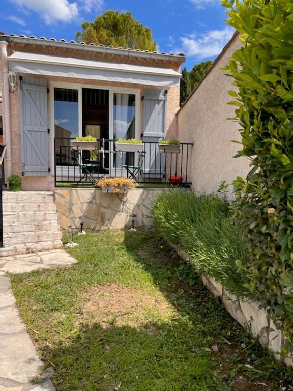 une maison avec une terrasse couverte munie d'une table. dans l'établissement Un petit coin sympa, à Draguignan